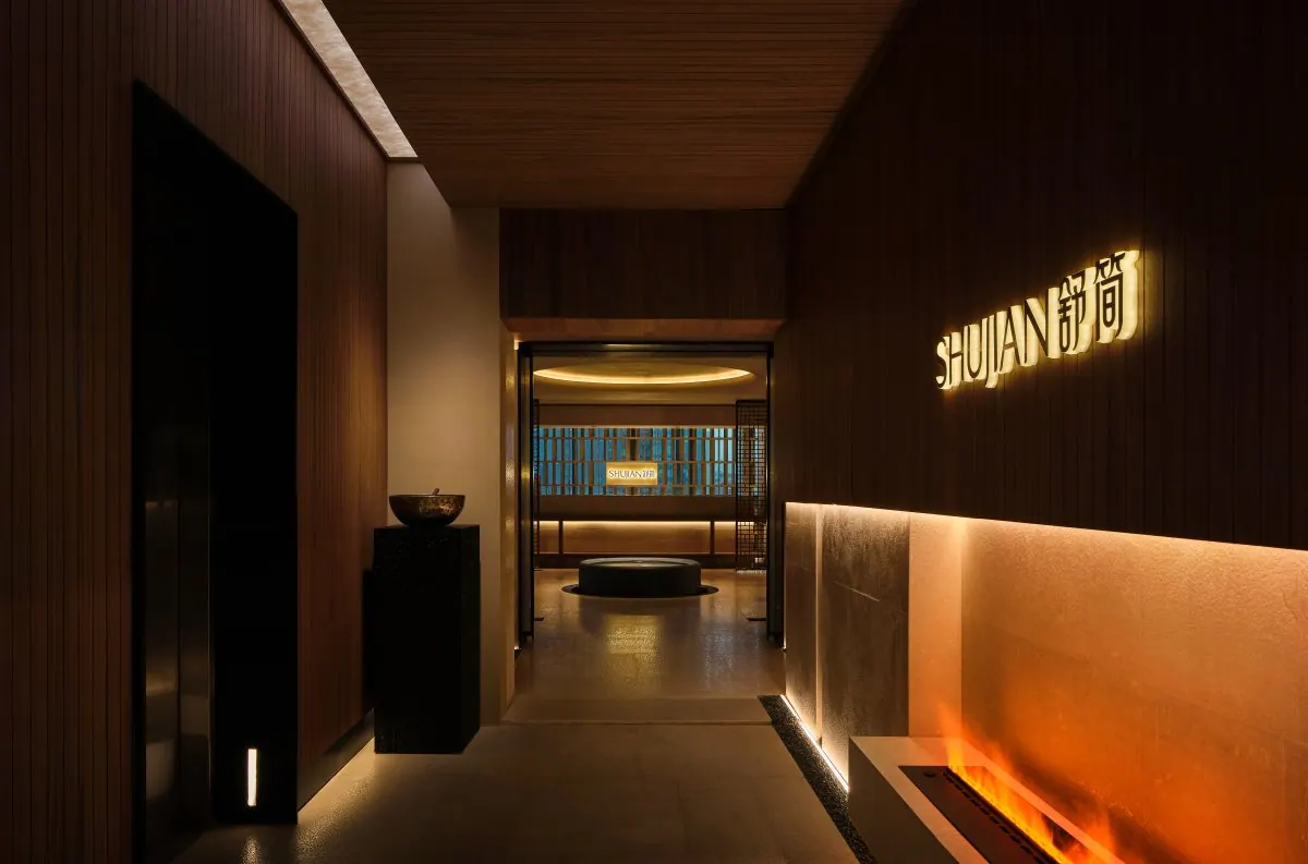 Warm timber and low lighting in the Shujian spa reception space